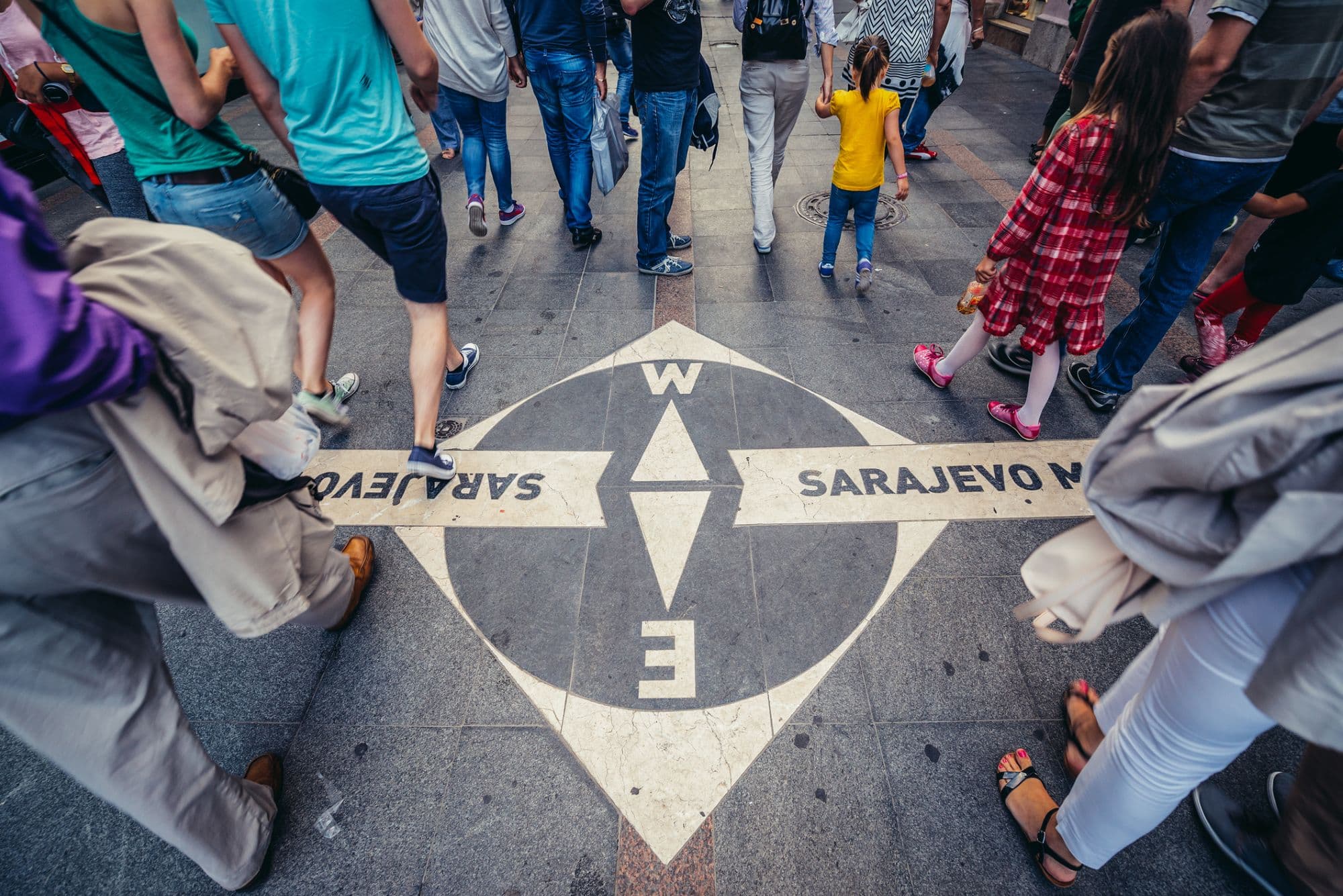 Pedestrians cross the Sarajevo Meeting of Cultures compass line in the Old Town, where the city's Eastern and Western halves meet.